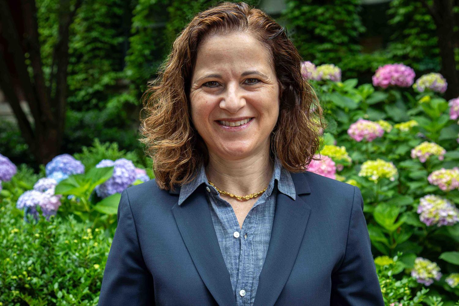 Photo of Provost Rebecca L. Walkowitz in front of hydrangeas